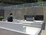 多摩教会墓前と祈る晴佐久神父